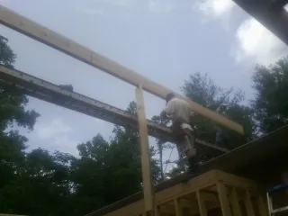Carpenter setting a ridge beam over a new addition frame — Ice Dam Removal by Roofing Brothers in Dacono